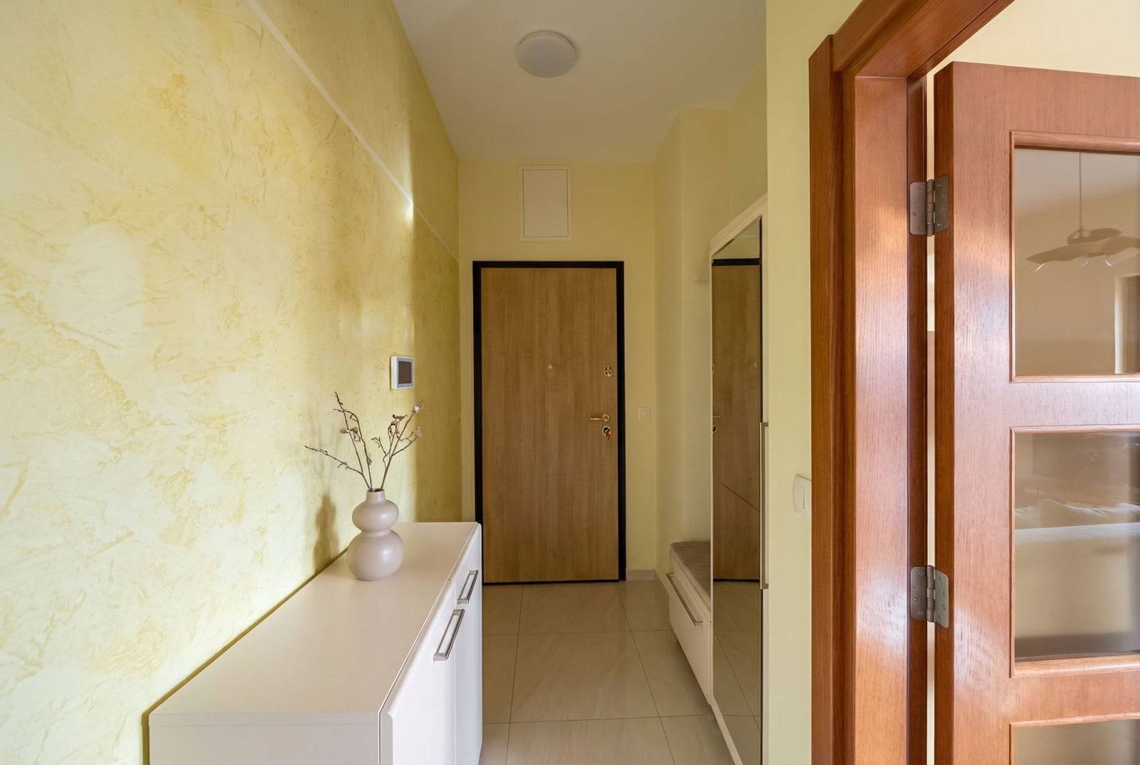 Bright hallway with a white cabinet and mirror in an apartment for sale in Petrovac, Montenegro.