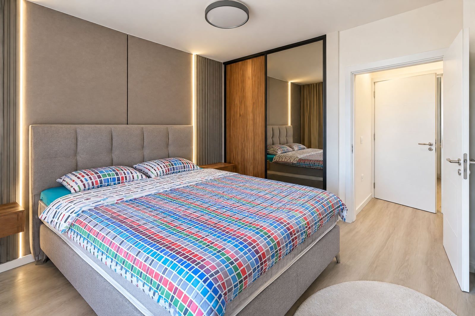 Modern bedroom with a soft double bed, a built-in wardrobe, and accent lighting in an apartment in Budva, Montenegro