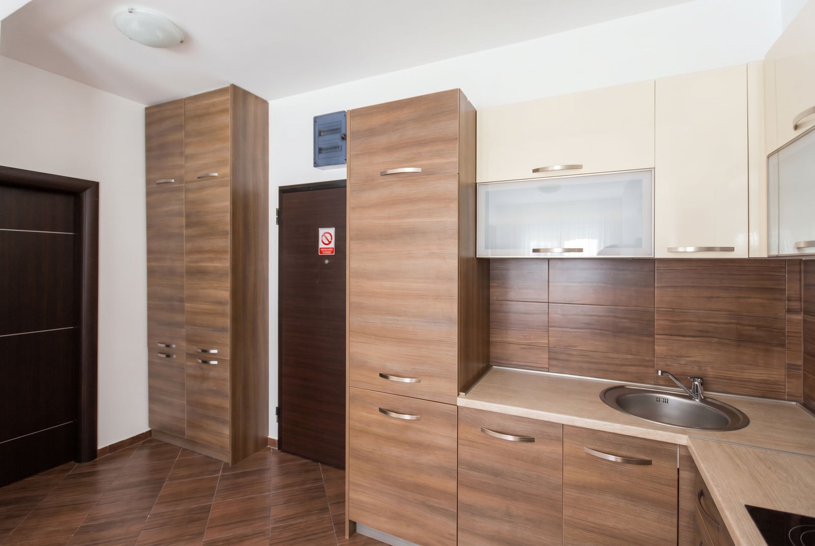 Modern kitchen with wooden cabinets in an apartment for sale in Budva, Montenegro: built-in furniture and sink.