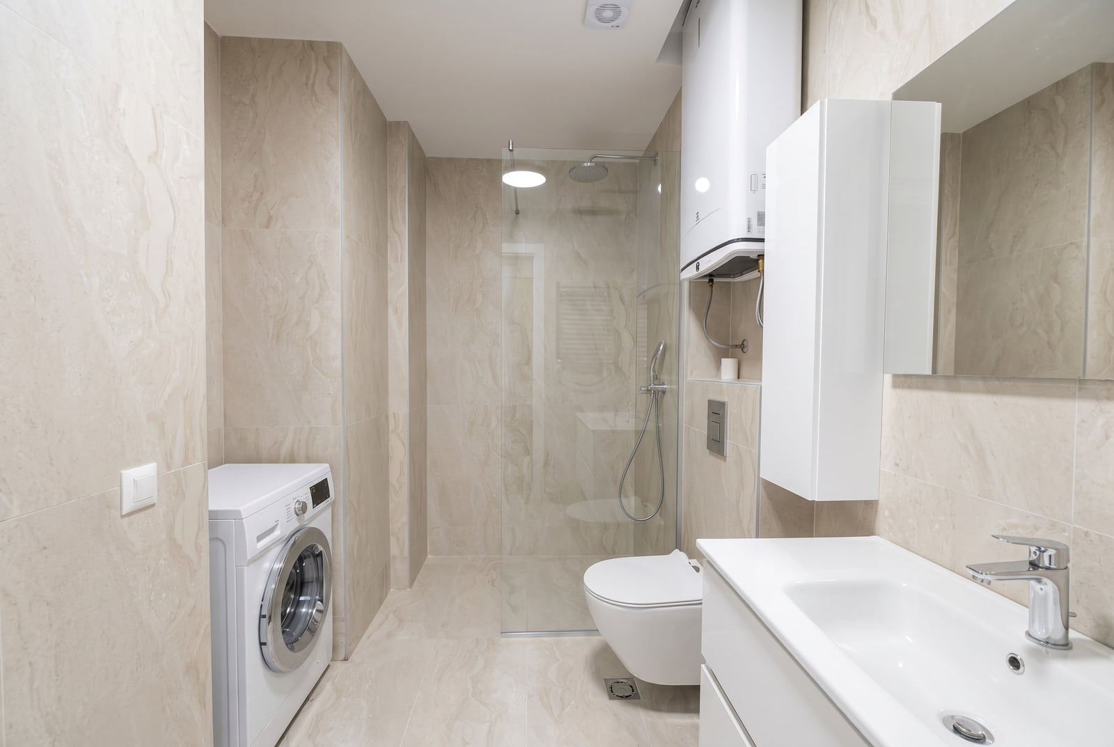 Modern bathroom with a shower cabin, sink, and washing machine in an apartment in Budva, Montenegro