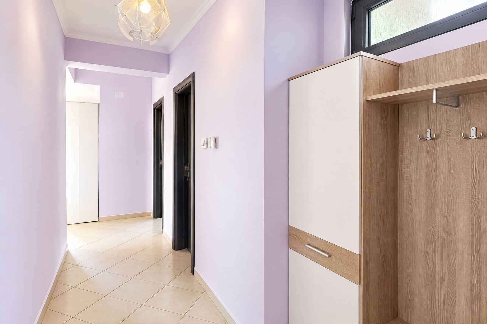 Bright hallway with furniture, light walls, and tile flooring in an apartment in Budva, Montenegro