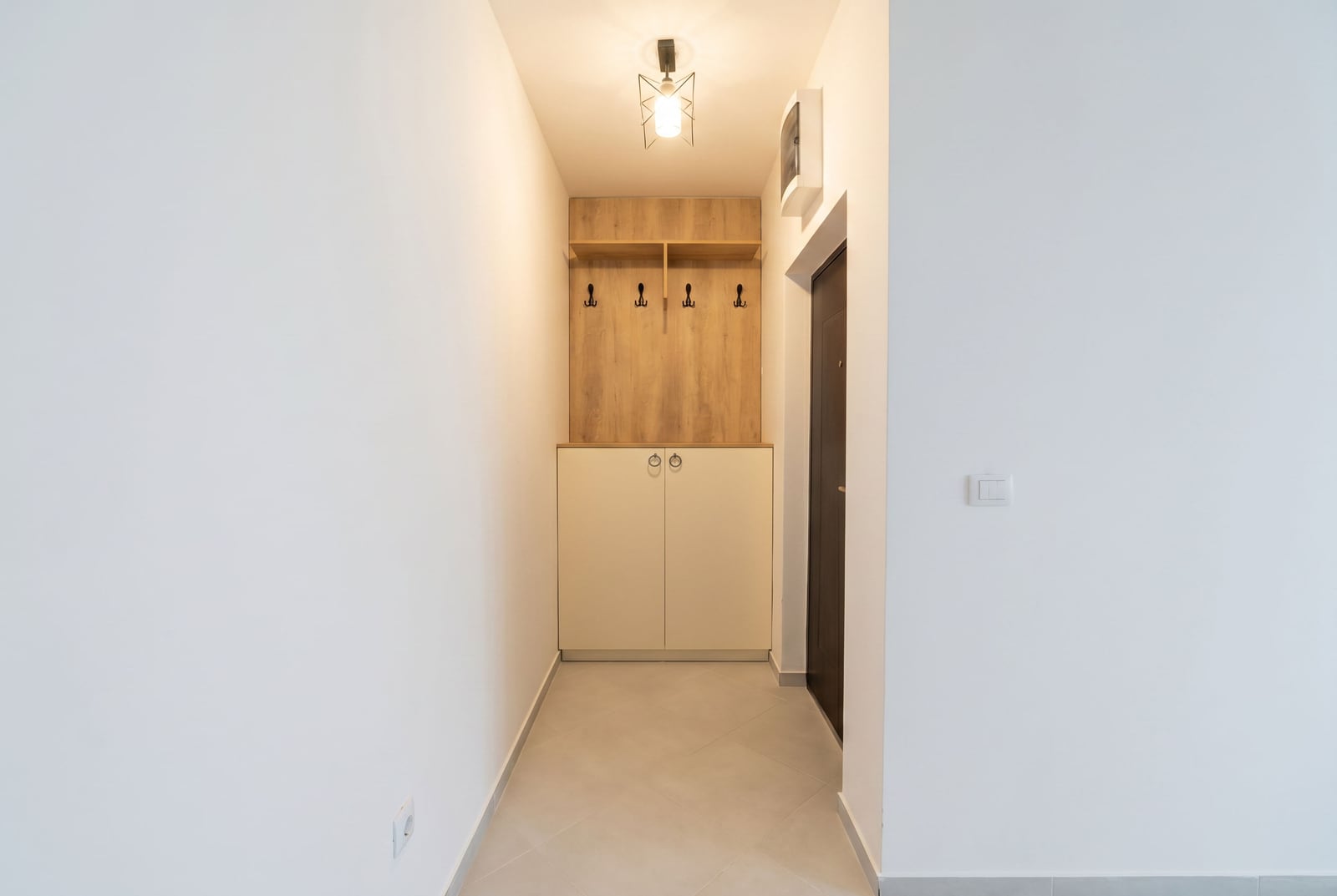 Jasny przedpokój z szafą wnękową i wieszakiem w apartamencie w Rafailovici, Czarnogóra. Nowoczesne wnętrze.