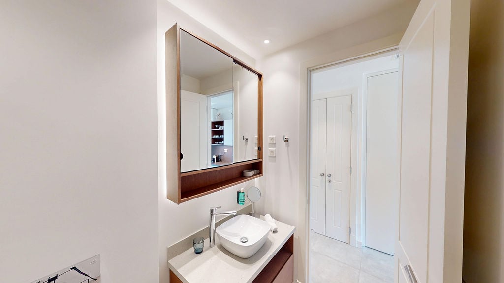 Modernes Badezimmer mit Spiegel und Waschtisch in einer Wohnung in Luštica, Montenegro: stilvolles Interieur und hochwertige Ausstattung.