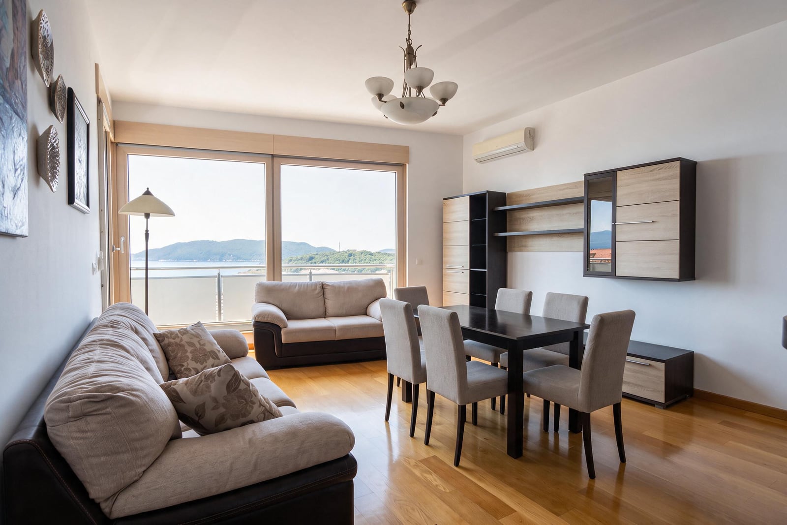 Spacious living room with panoramic windows, furniture, and sea view in an apartment in Bečići, Montenegro.