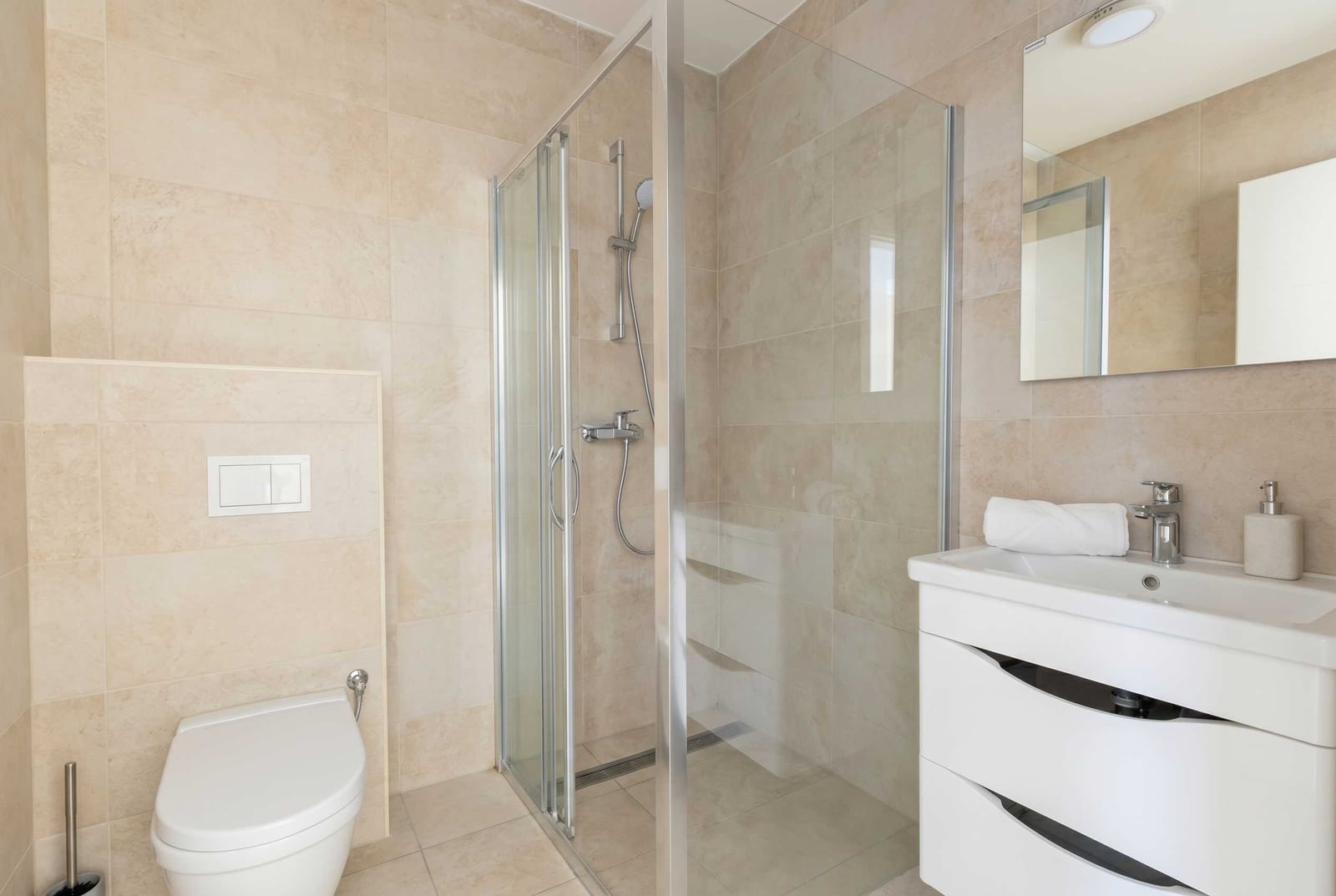 Modernes Badezimmer mit Dusche und hellen Fliesen in einer zum Verkauf stehenden Wohnung in Kavač, Montenegro.