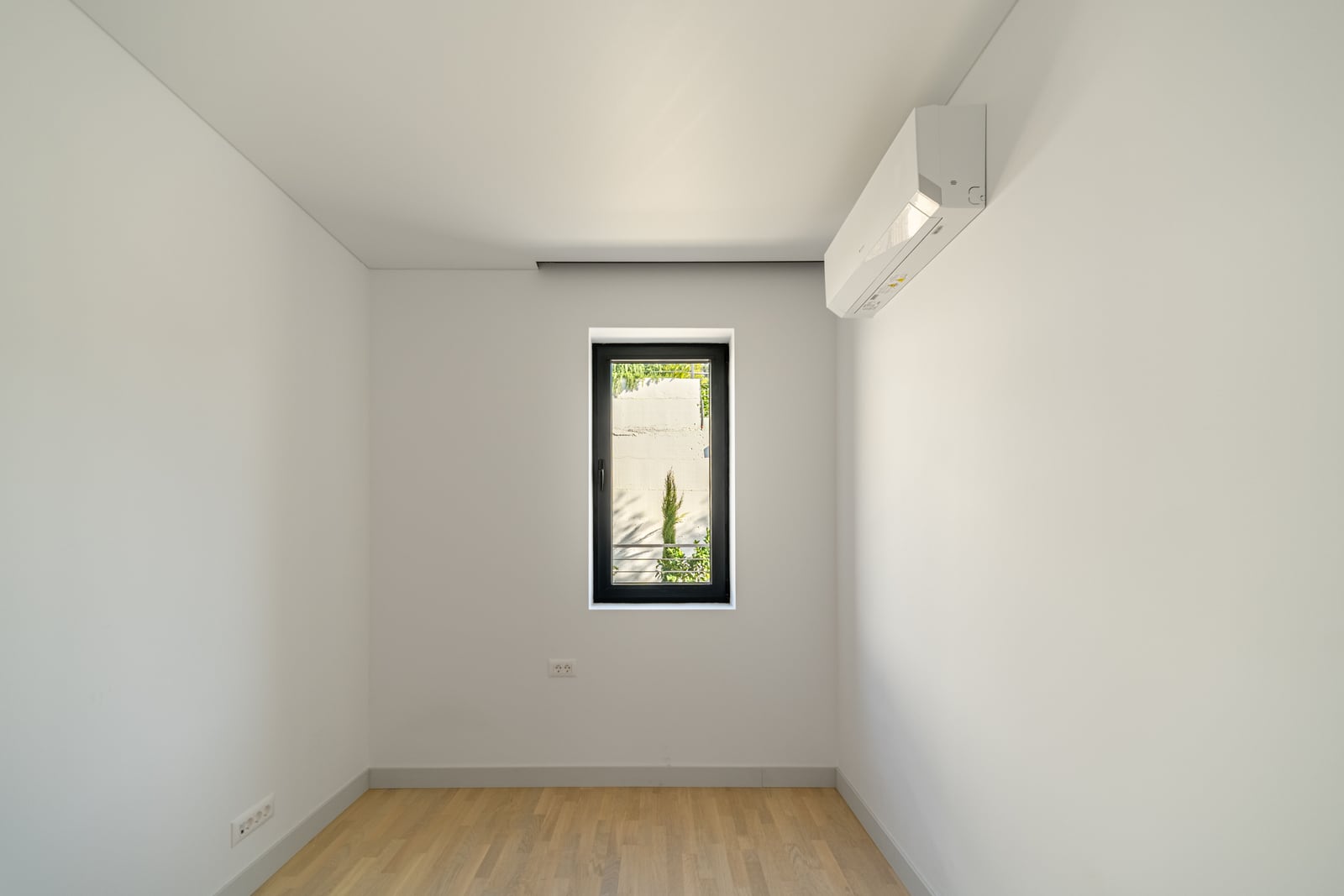 Kavaç, Karadağ'daki bir townhouse'da parke zeminli, klimalı ve pencereli aydınlık yatak odası. Modern minimalist iç mekan.