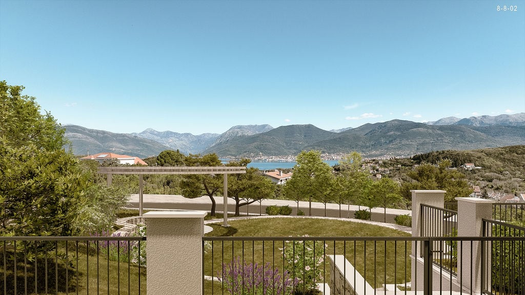 Panoramski pogled na planine i more iz stambenog kompleksa u Luštici, Crna Gora, sa uređenom terasom i baštom.