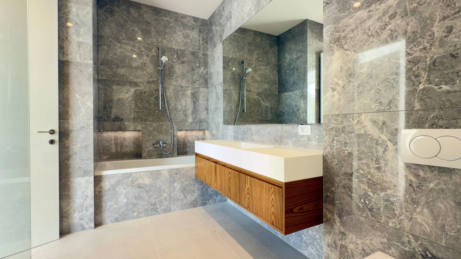 Modernes Badezimmer mit grauer Marmorverkleidung und Holzwaschtisch in einer Villa in Krašići, Montenegro.