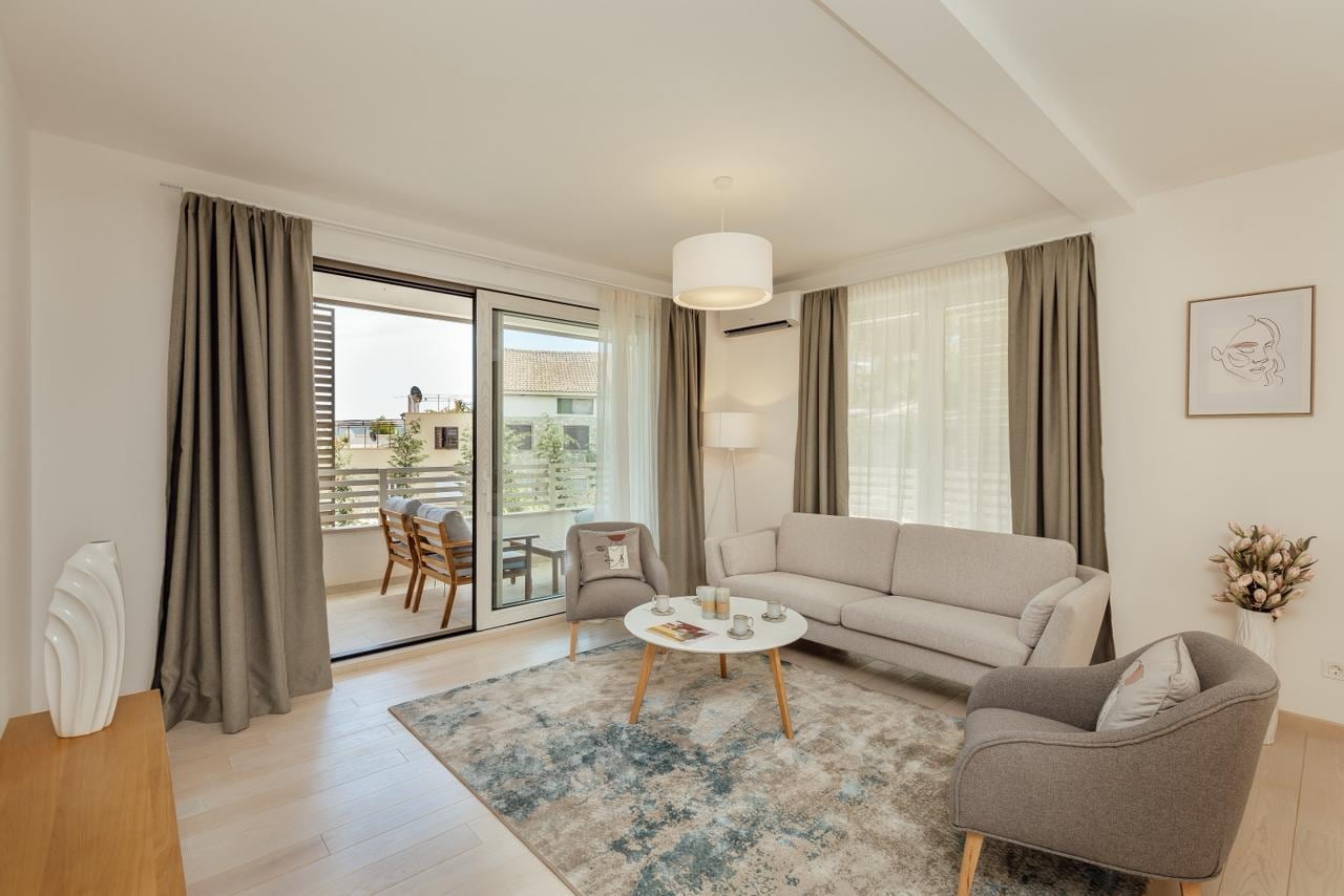 Helles Wohnzimmer mit Möbeln und Zugang zur Terrasse in einer Wohnung in Igalo, Herceg Novi, Montenegro.