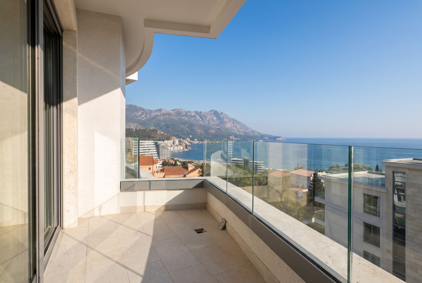 Spacious balcony with panoramic glazing and sea and mountain views in Becici, Montenegro