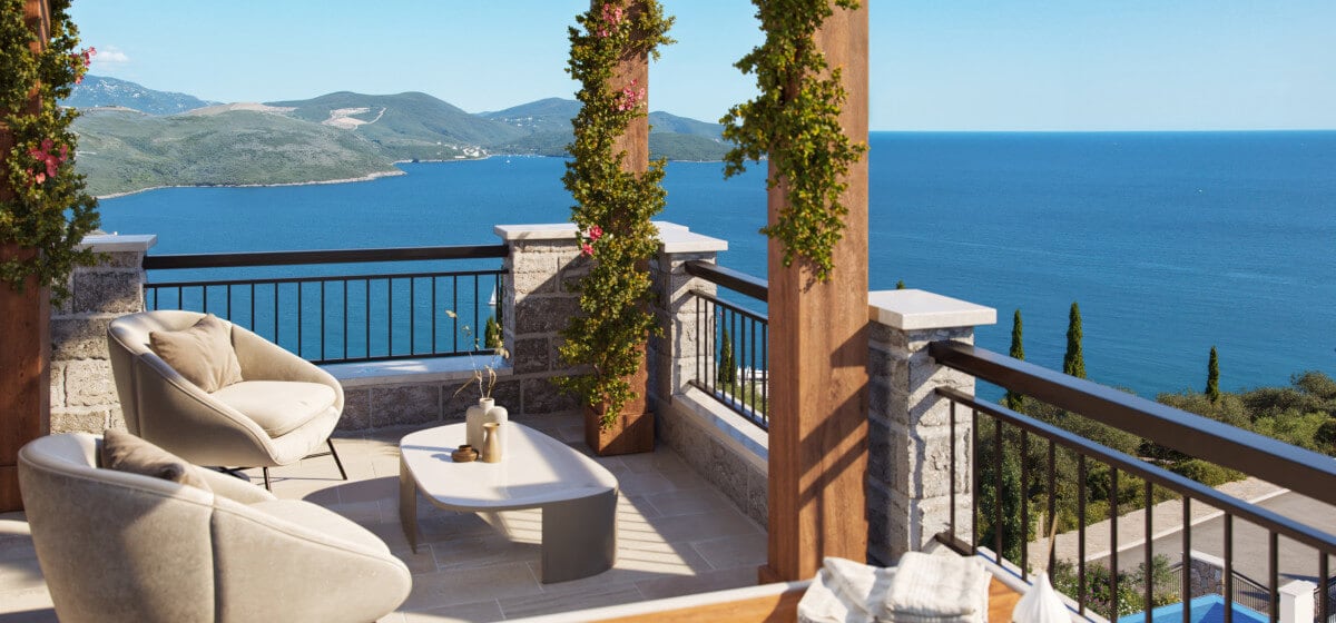 Terrasse mit bequemen Sesseln und Meerblick im Wohnkomplex Luštica, Montenegro: Steinverkleidung und Blumendekoration.