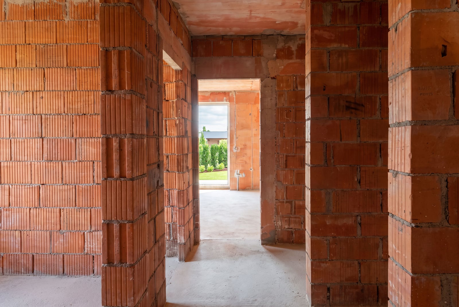 Rough finish in a new development in Tivat: brick walls without renovation, view of greenery from the windows. Apartment in Montenegro.