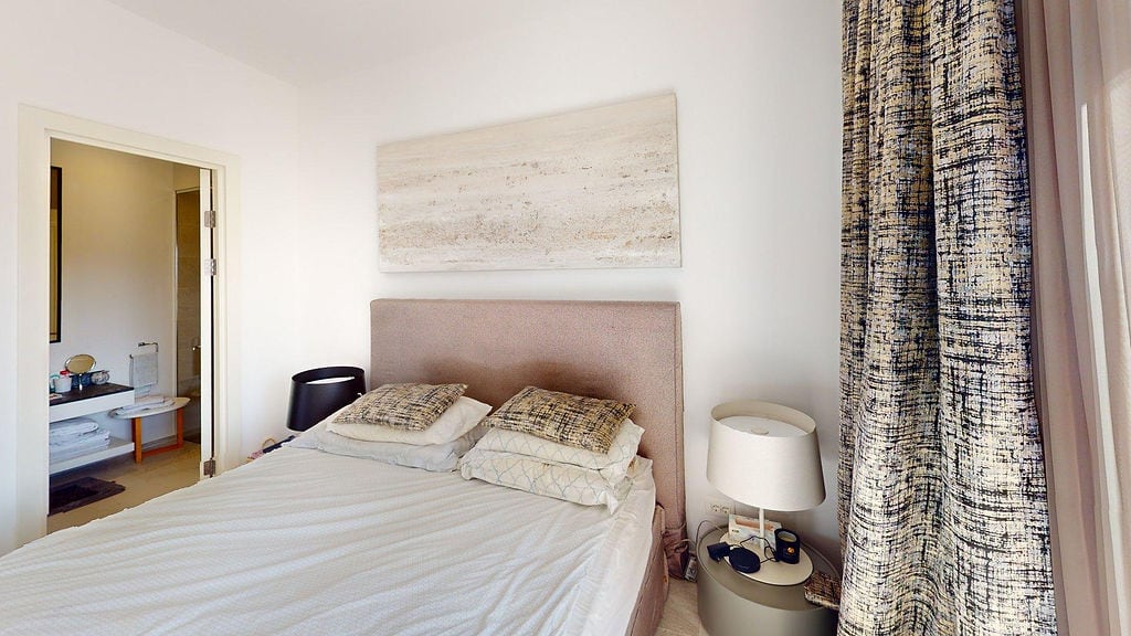 Udobna spavaća soba sa bračnim krevetom i kupatilom u apartmanima Luštica, Crna Gora. Moderan enterijer.