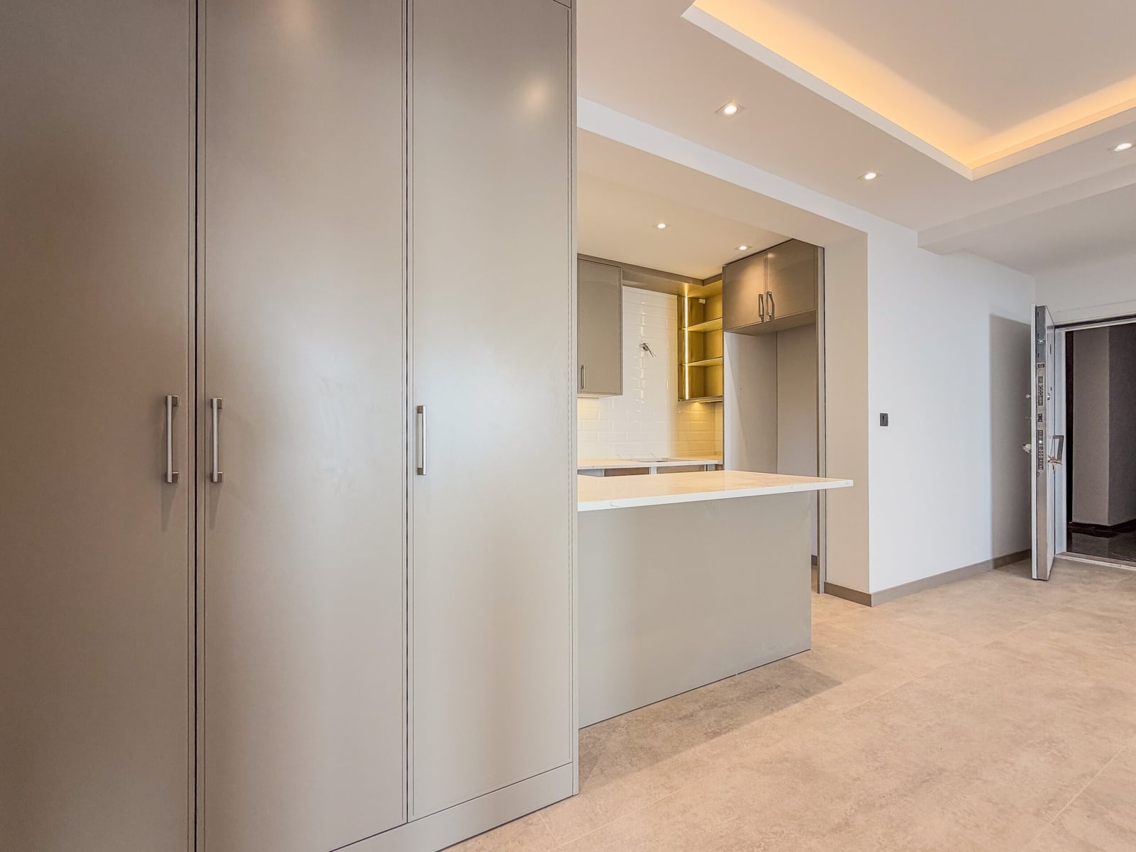 Modern kitchen in an apartment in Budva, Montenegro: light-colored furniture, built-in cabinets, and a kitchen island.