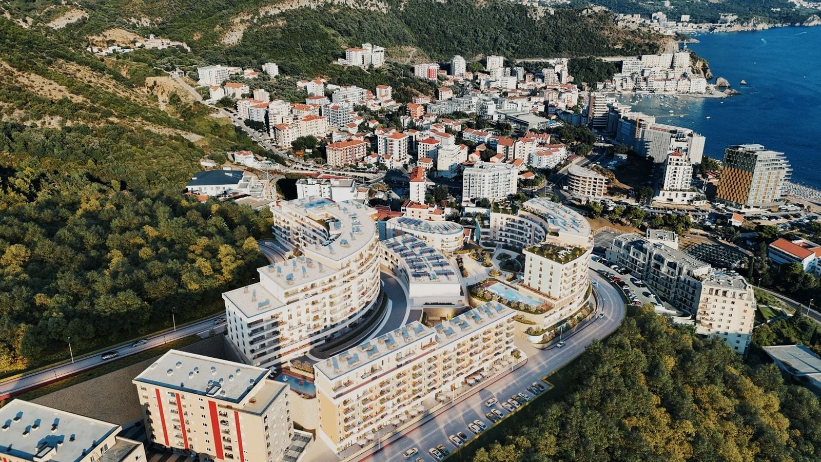 Karadağ, Bečići’de havuzları ve Adriyatik Denizi’ne panoramik manzarası olan modern bir konut kompleksi havadan görünüm.