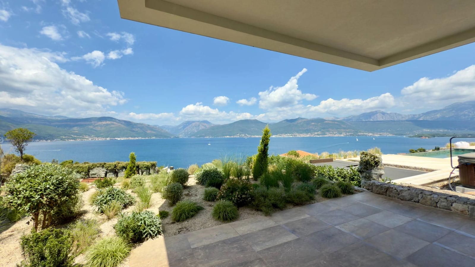 Panoramablick auf Meer und Berge von der Terrasse der Villa in Krašići, Montenegro: Landschaftsgestaltung und Fliesenbelag.