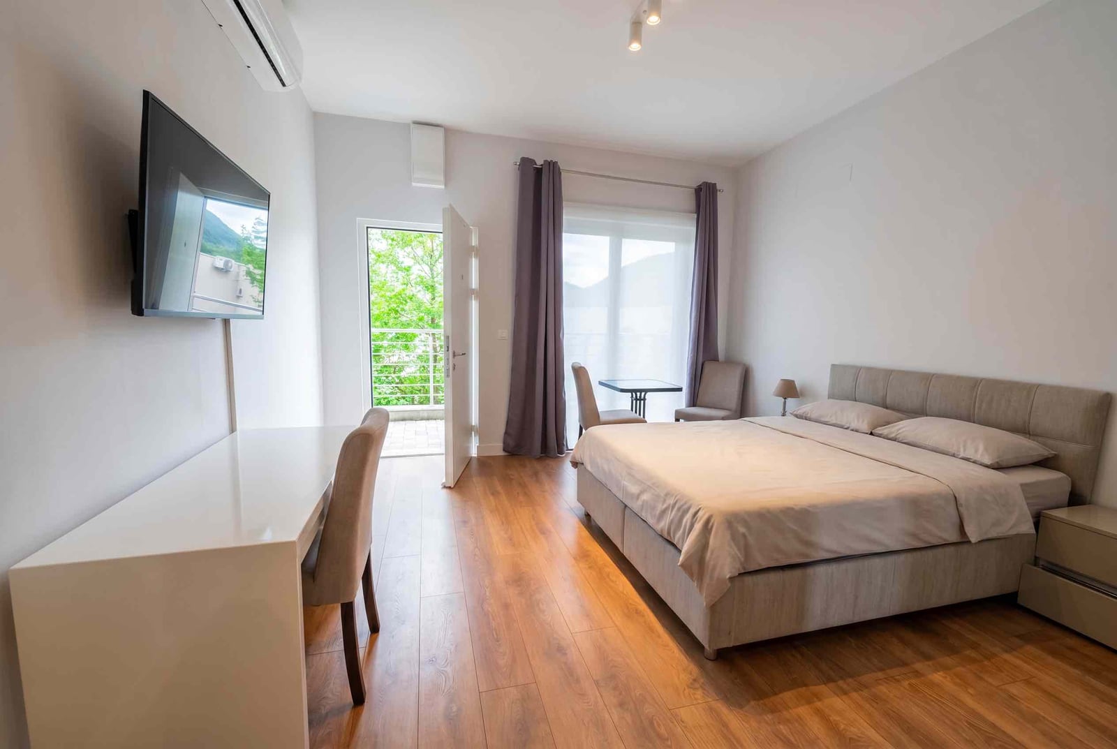 Modernes Schlafzimmer mit Doppelbett und Zugang zum Balkon in einer Wohnung, Kavač, Montenegro.