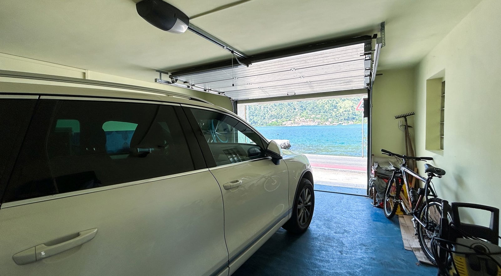 Garage mit Auto und Meerblick in einer Villa, Dobrota, Montenegro. Geräumiger Raum mit automatischem Tor.