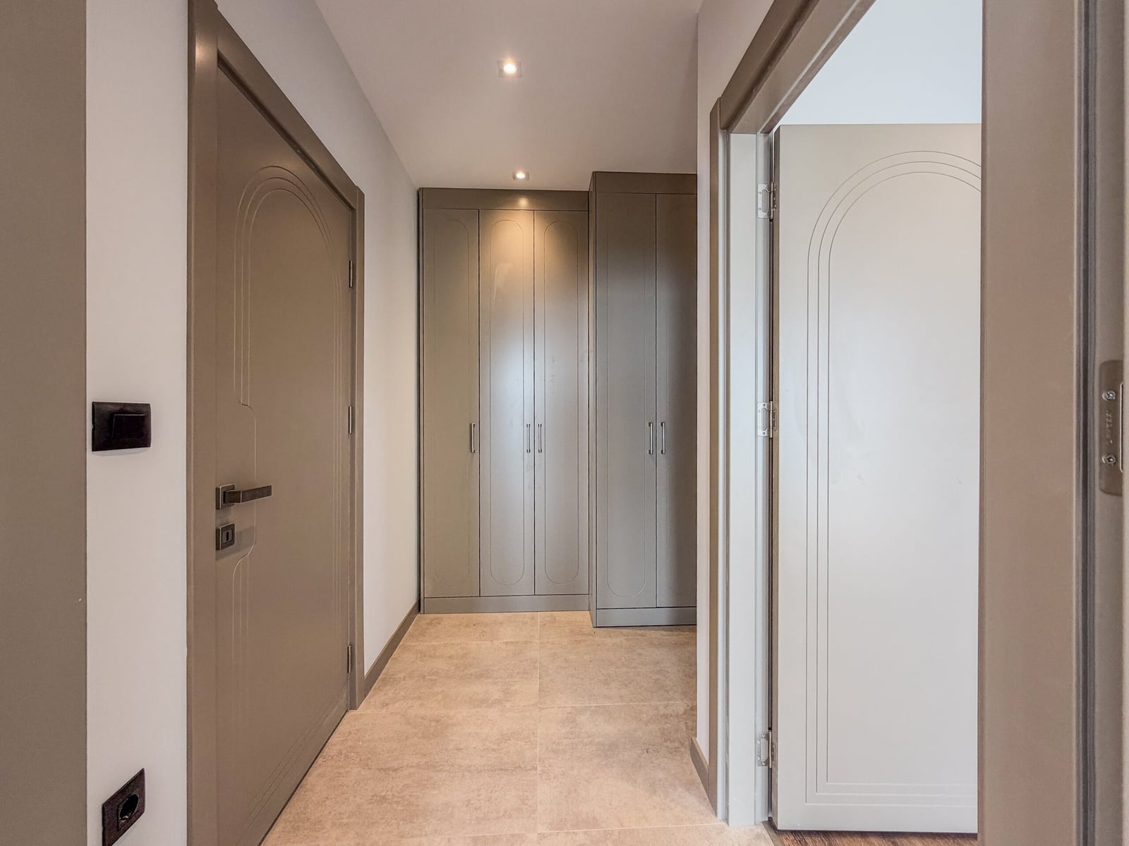 Modern hallway with gray built-in furniture and interior doors in an apartment in Budva, Montenegro