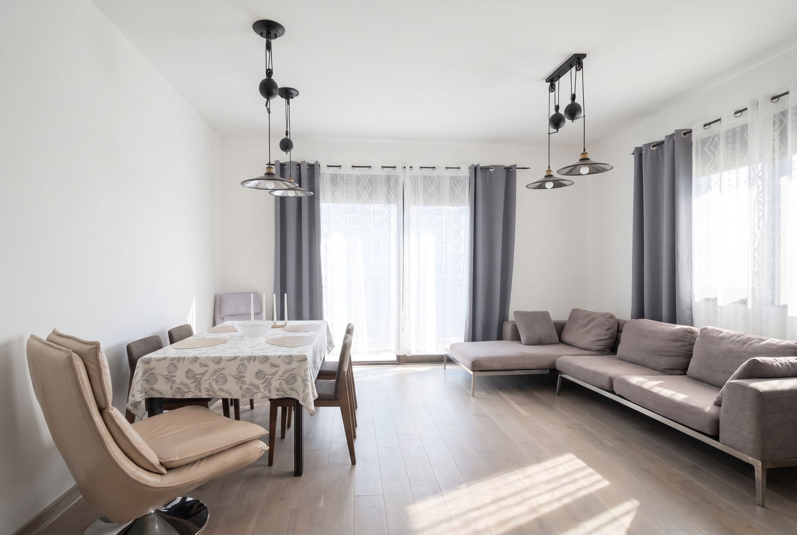 Geräumiges Wohnzimmer mit bequemer Ecksofa, Essbereich und Panoramafenstern in einer Wohnung in Budva, Montenegro