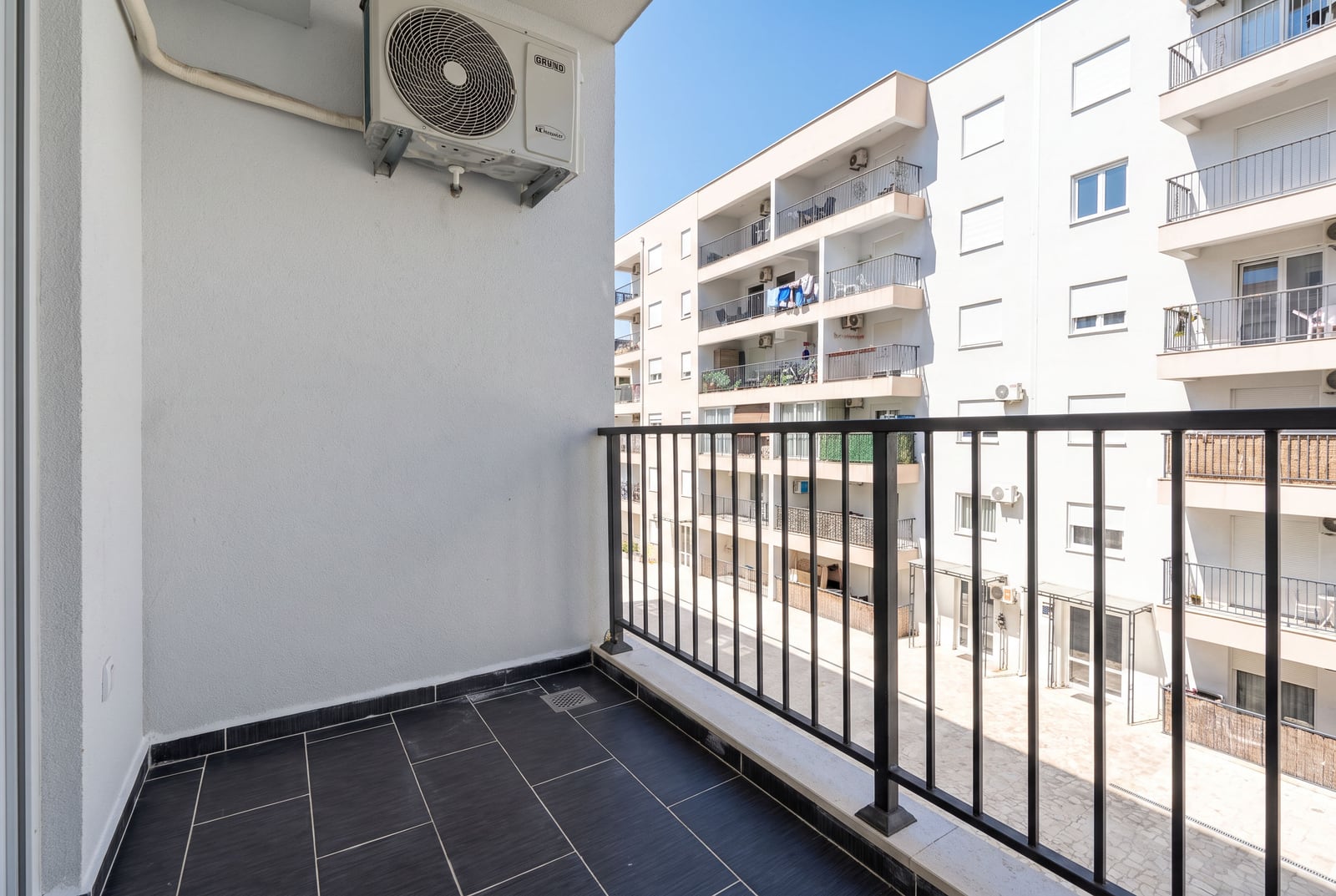 Balkon sa tamnim pločicama i klima uređajem u stanu u Budvi, Crna Gora