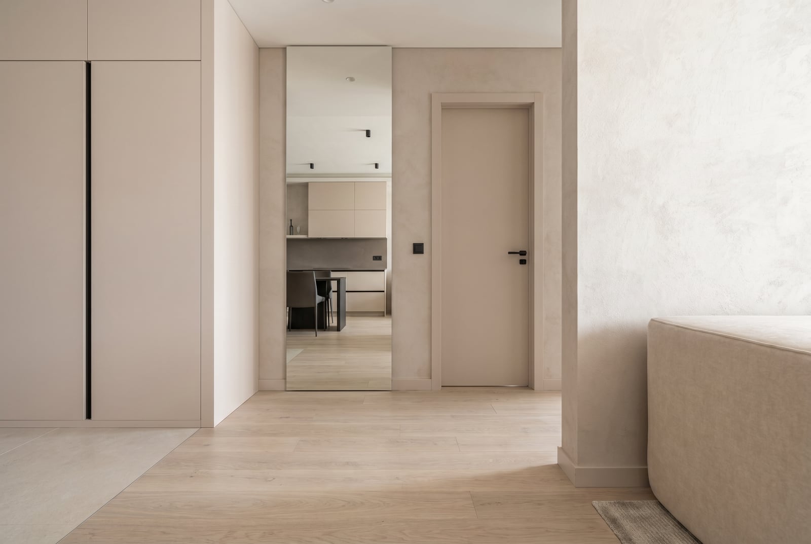 Modernes Wohnzimmerinterieur in hellen Tönen mit Spiegel und Einbauschrank in der Wohnanlage Tivat, Montenegro.