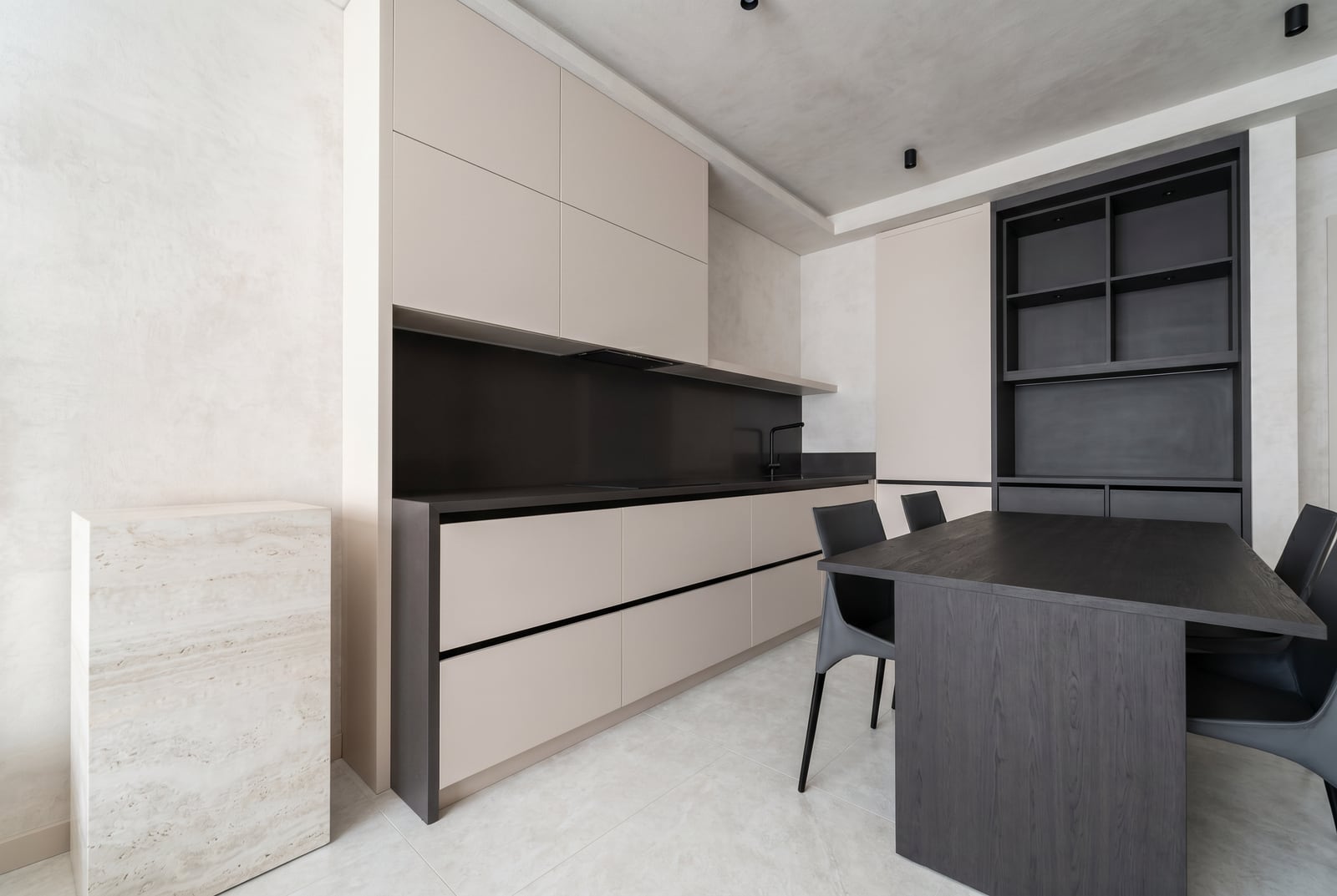 Moderne Küche im minimalistischen Stil mit schwarzen Möbeln und einem Essbereich in der Wohnung, Stadt Tivat, Montenegro.