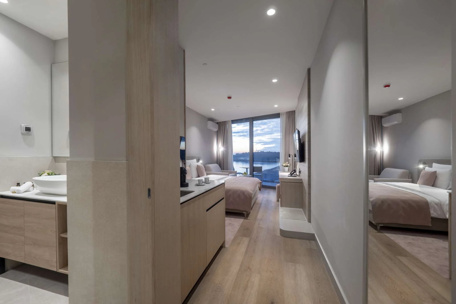Moderna spavaća soba sa panoramskim pogledom na more, bračnim krevetom i kupatilom u hotelu Bečići, Crna Gora