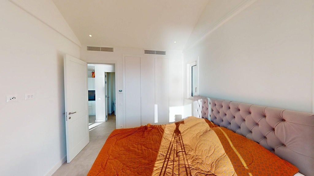 Helles Schlafzimmer mit Bett und Einbauschrank in der Wohnanlage Lustica Bay, Luštica, Montenegro.
