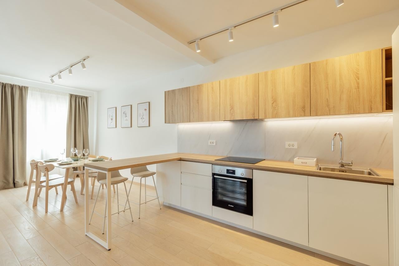 Moderne Wohnküche in einem Apartment, Igalo, Montenegro: helle Möbel, Bartheke und Essbereich.