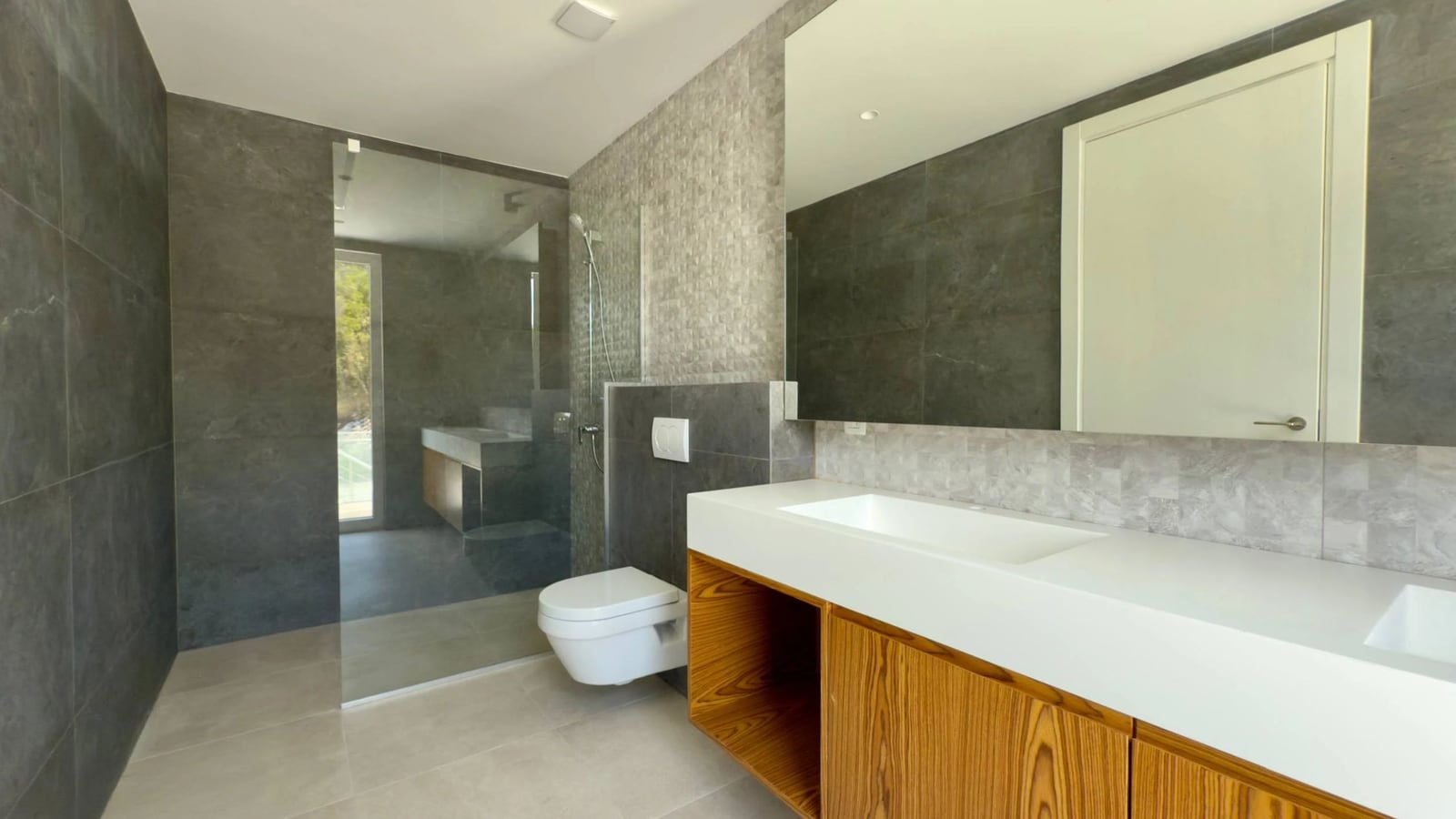 Modernes Badezimmer in einer Villa in Krašići, Montenegro: Duschkabine, stilvoller Waschtischunterschrank und Feinsteinzeugverkleidung.
