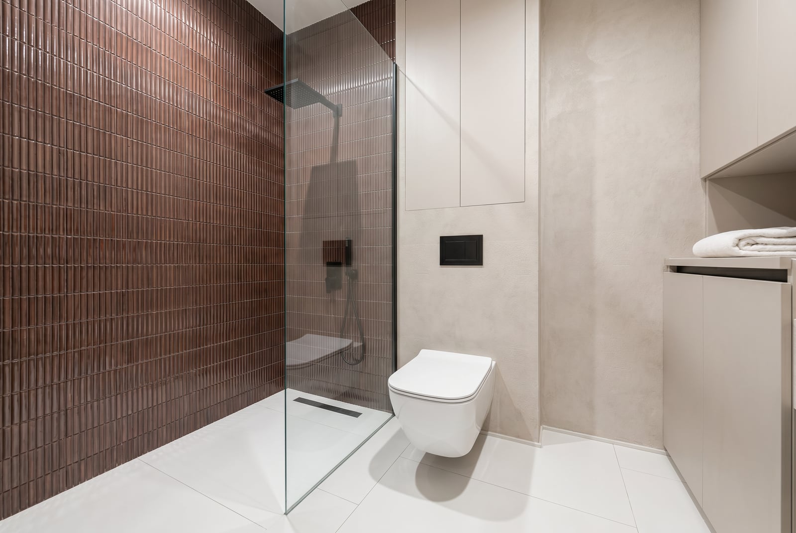 Modernes Badezimmer in einer Wohnung, Tivat, Montenegro: Dusche, braune Fliesen und Sanitäranlagen.
