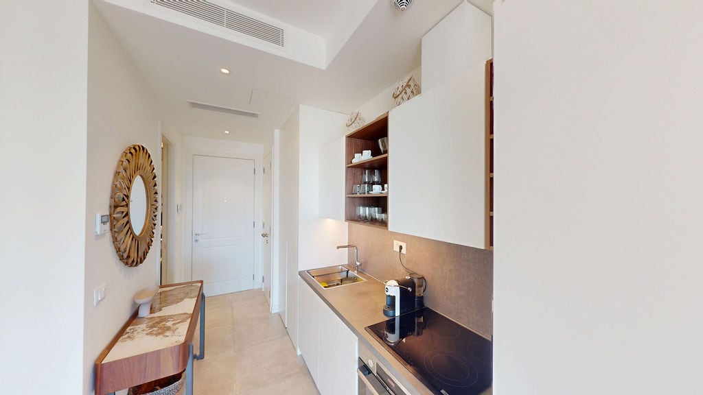 Moderne Küche in einer Wohnung in Luštica, Montenegro: Einbauküche, stilvolle Dekoration und Spiegel im Flur.