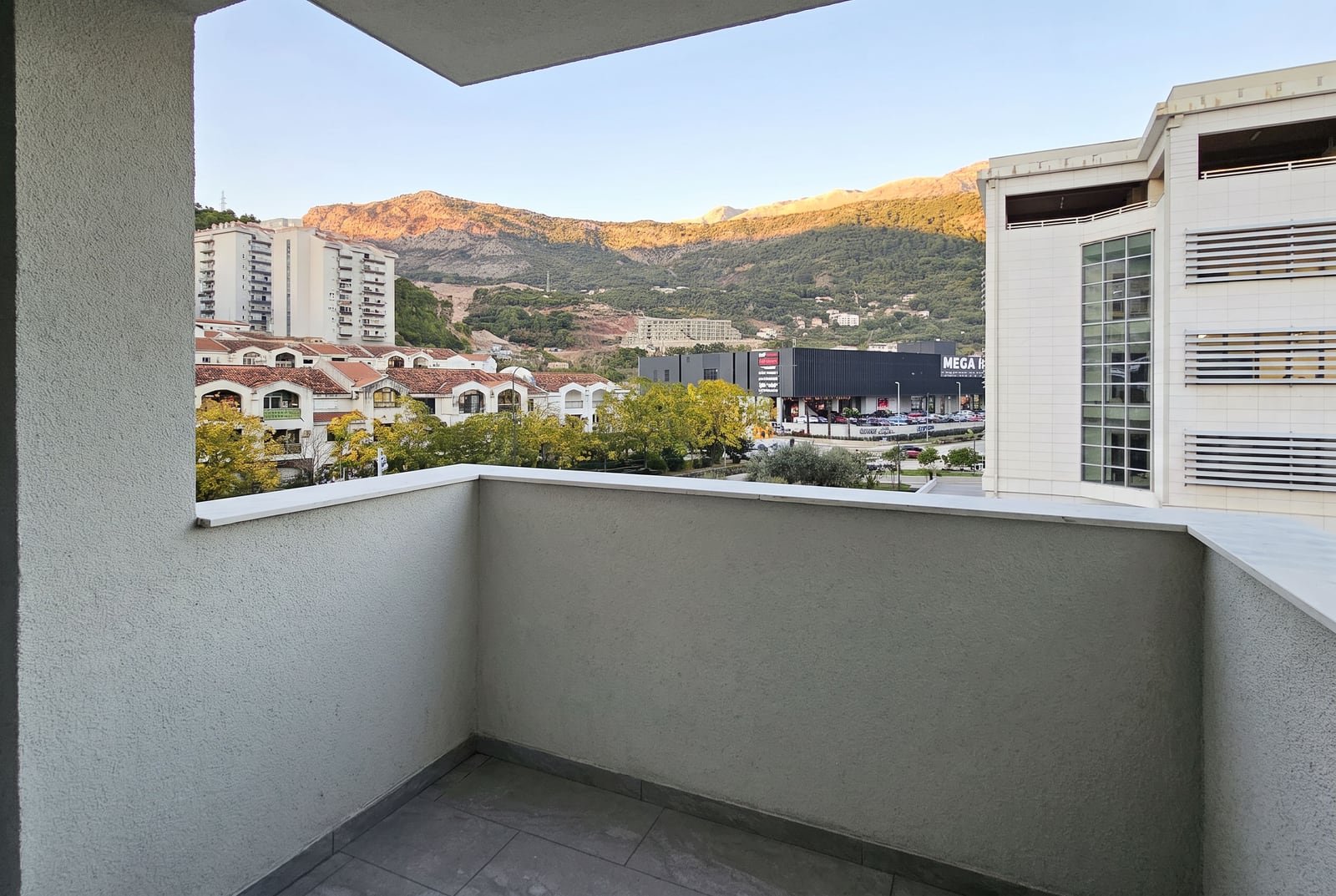 View from the apartment balcony in Budva overlooking the mountains and the city: unfinished interior, tile flooring, Montenegro