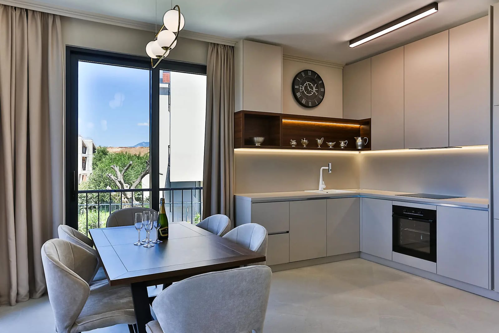 Modern kitchen and dining area in a villa in Reževići, Montenegro: stylish cabinetry, dining space, and panoramic window.