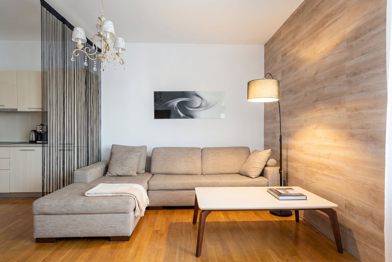 Moderna dnevna soba u stanu u Budvi, Crna Gora: ugaona sofa, stočić za kafu i stilski drveni detalji.