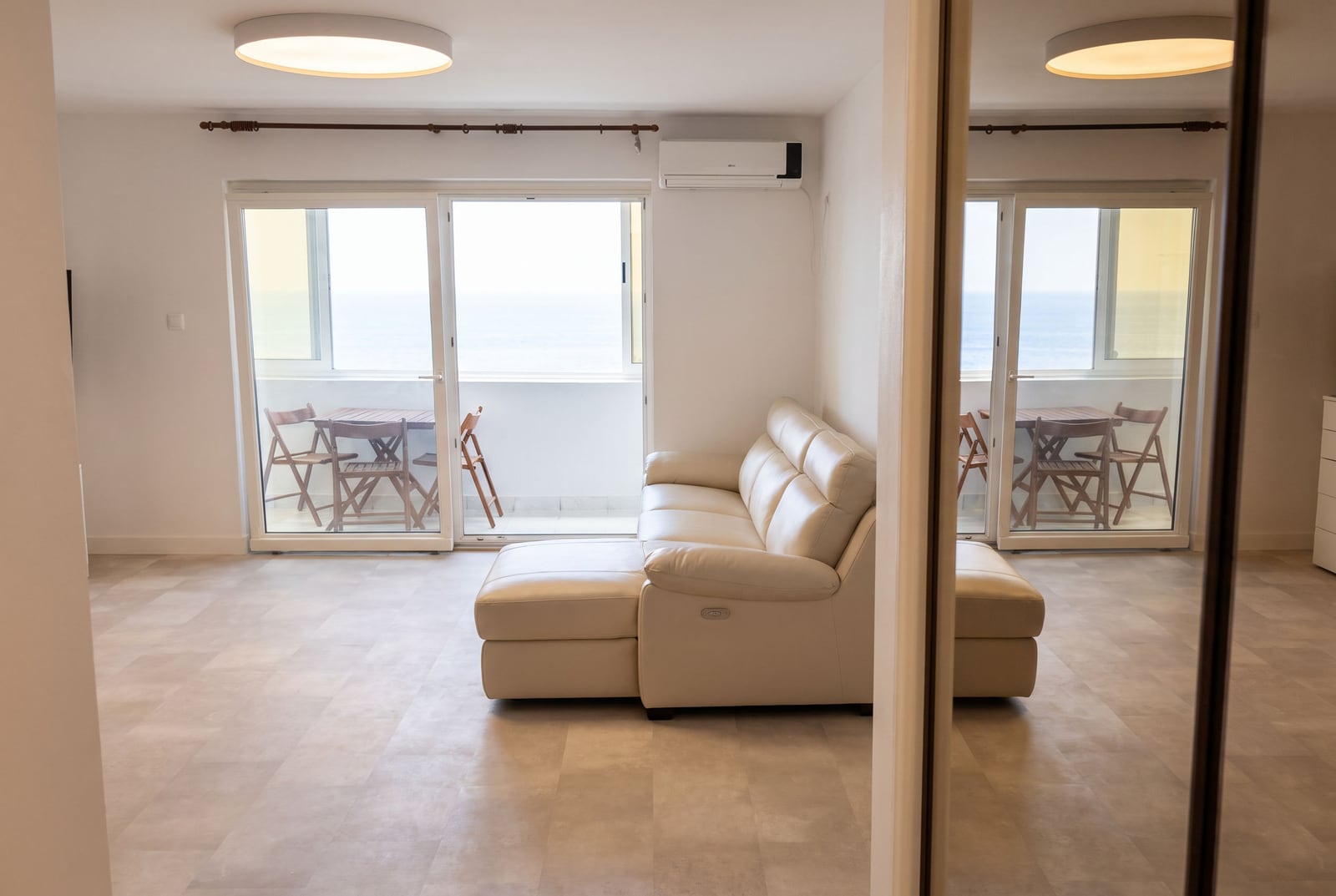 Bright living room with a leather sofa and access to a terrace with sea views in an apartment, Sveti Stefan, Montenegro.