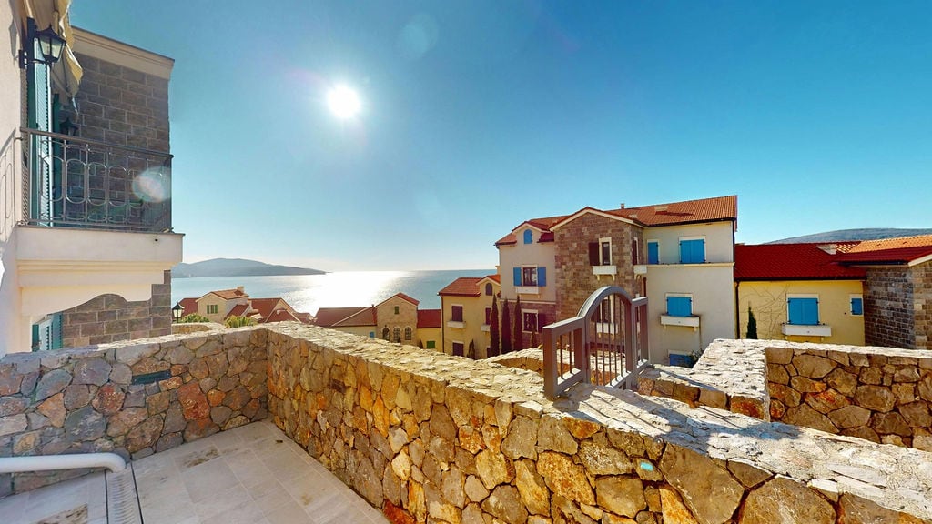 Taş kaplamalı teras ve Karadağ, Luštica Bay yerleşkesinde denize panoramik manzara.