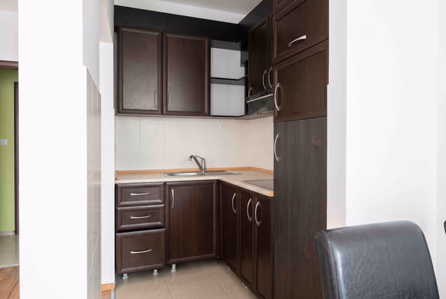 Kompakte Küche mit dunkler Küchenzeile in einer zum Verkauf stehenden Wohnung in Bečići, Montenegro: moderne Ausstattung und Geräte.