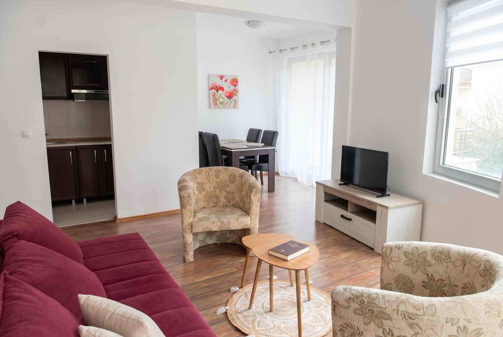 Salon z meblami wypoczynkowymi i jadalnią w apartamencie w Becici, Czarnogóra: nowoczesne wnętrze z kuchnią.