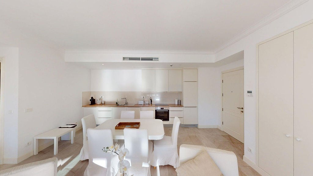 Moderne Küche-Esszimmer in hellen Tönen in der Wohnung des Wohnkomplexes Luštica, Montenegro: Einbaugeräte und Essbereich.