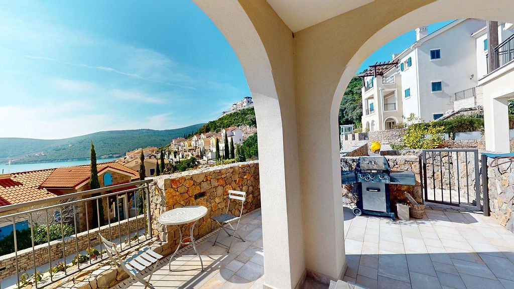 Terasa sa roštiljem i pogledom na more u stambenom kompleksu Luštica, Crna Gora: kamena obrada, nameštaj za odmor.