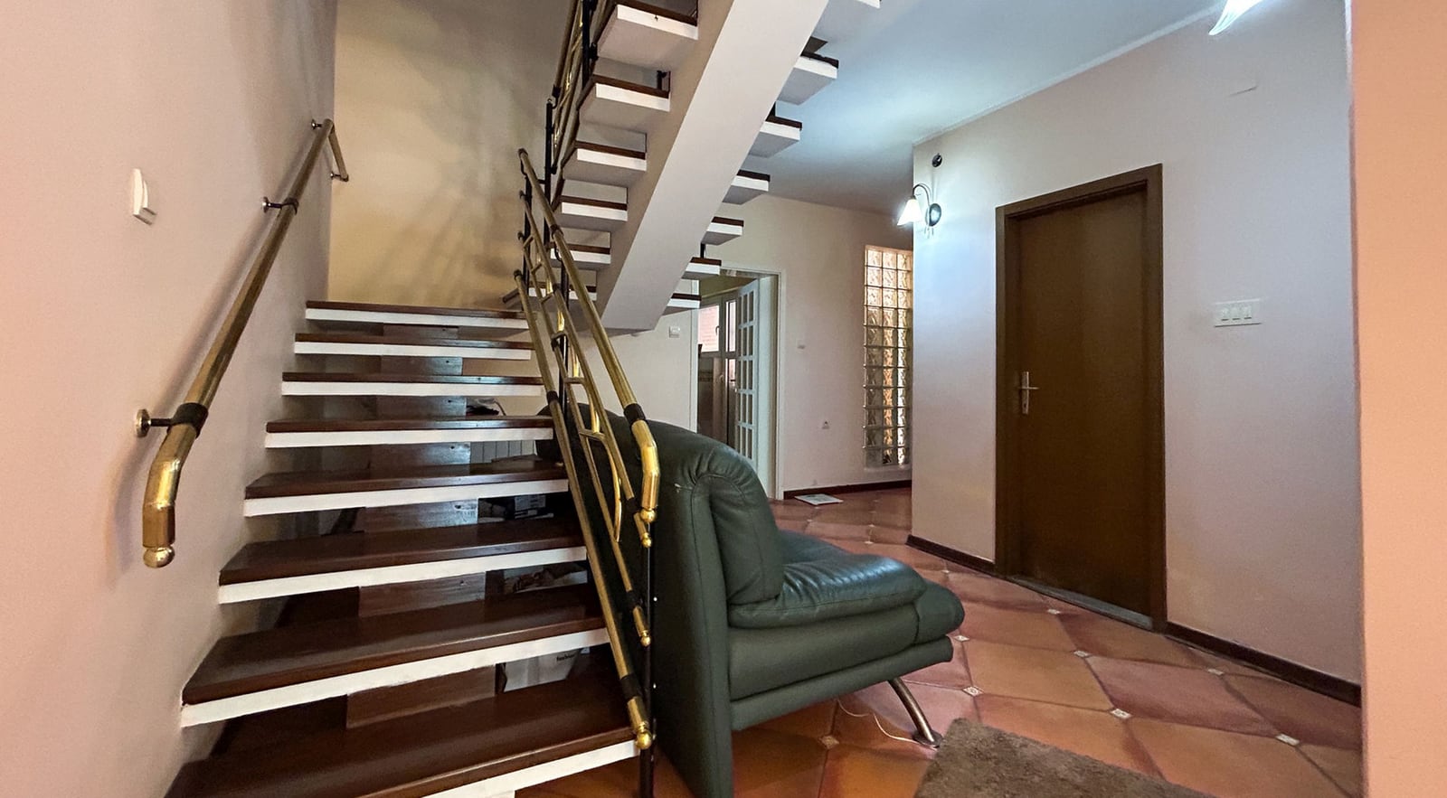 Innenraum des Wohnzimmers mit Holztreppe und Ledersofa in einer Villa in Dobrota, Montenegro.