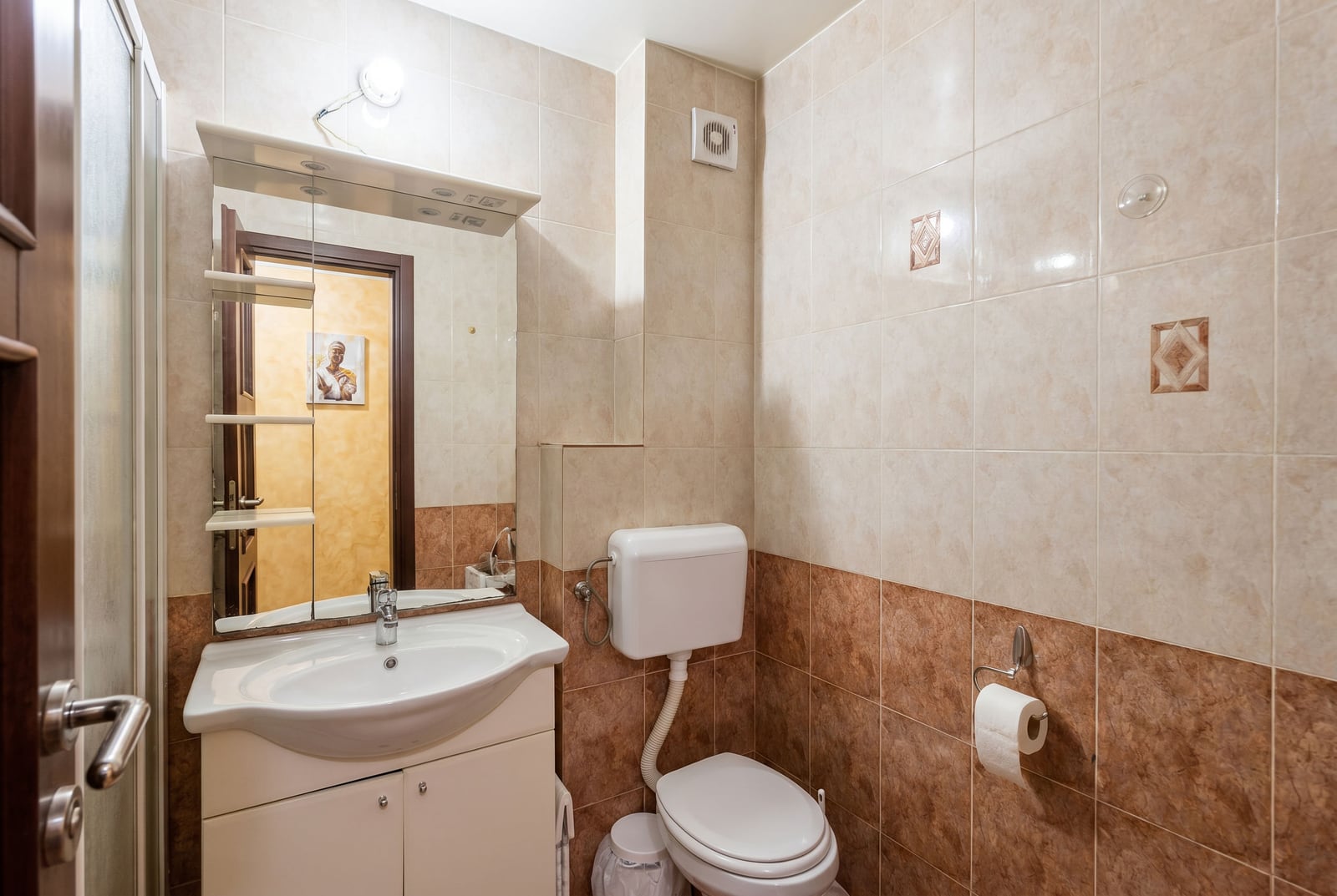 Bathroom with a shower cabin and light-colored tiles in an apartment for sale in Budva, Montenegro.