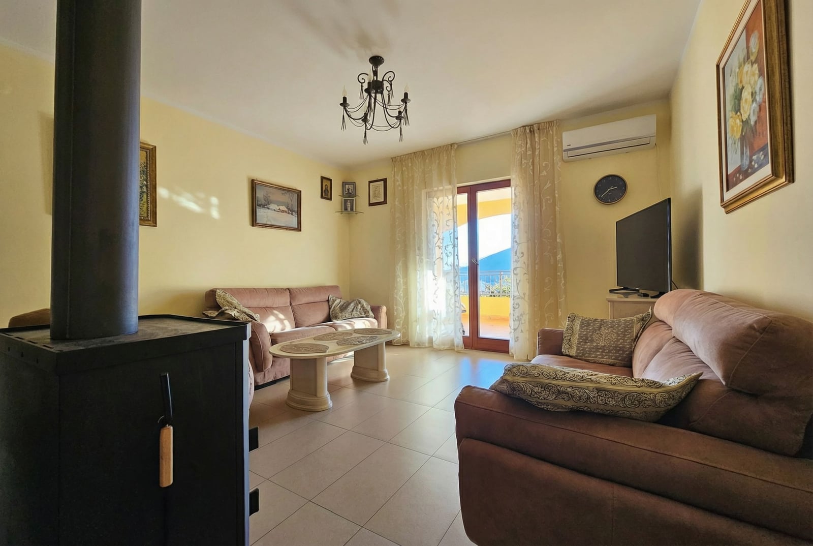 Living room with furniture, fireplace, and balcony access in an apartment in Igalo, Montenegro