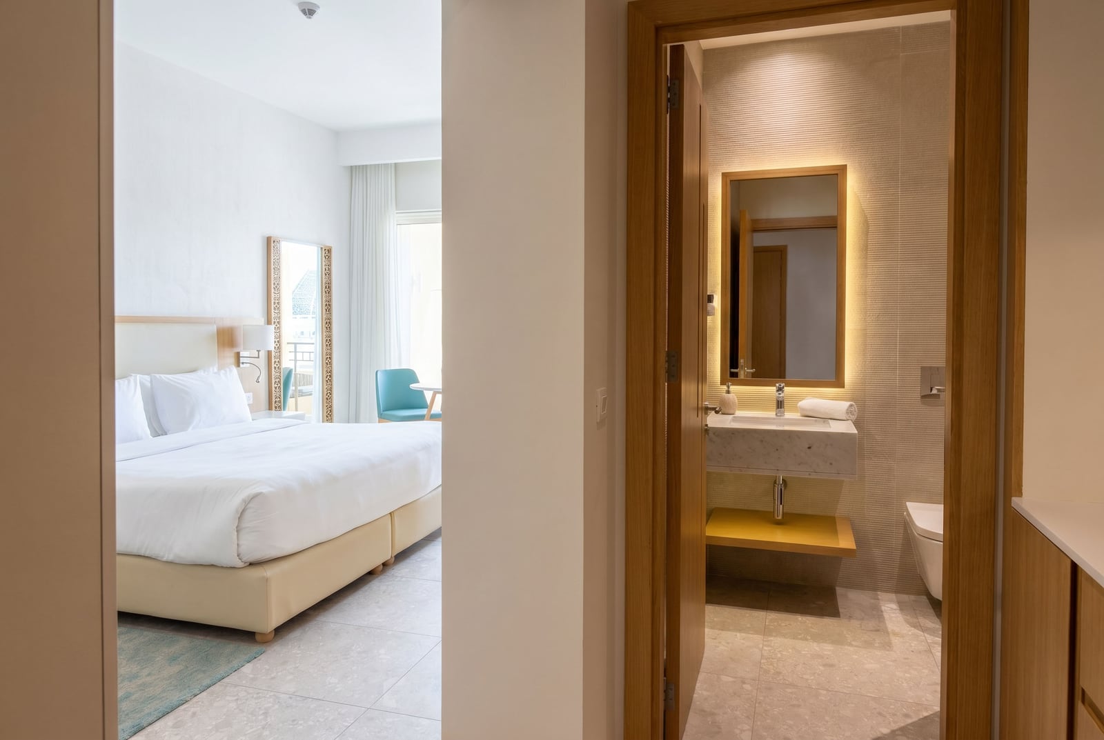 Modernes Schlafzimmer und Badezimmer im Apartment in Luštica Bay, Montenegro: helles Interieur, Doppelbett.