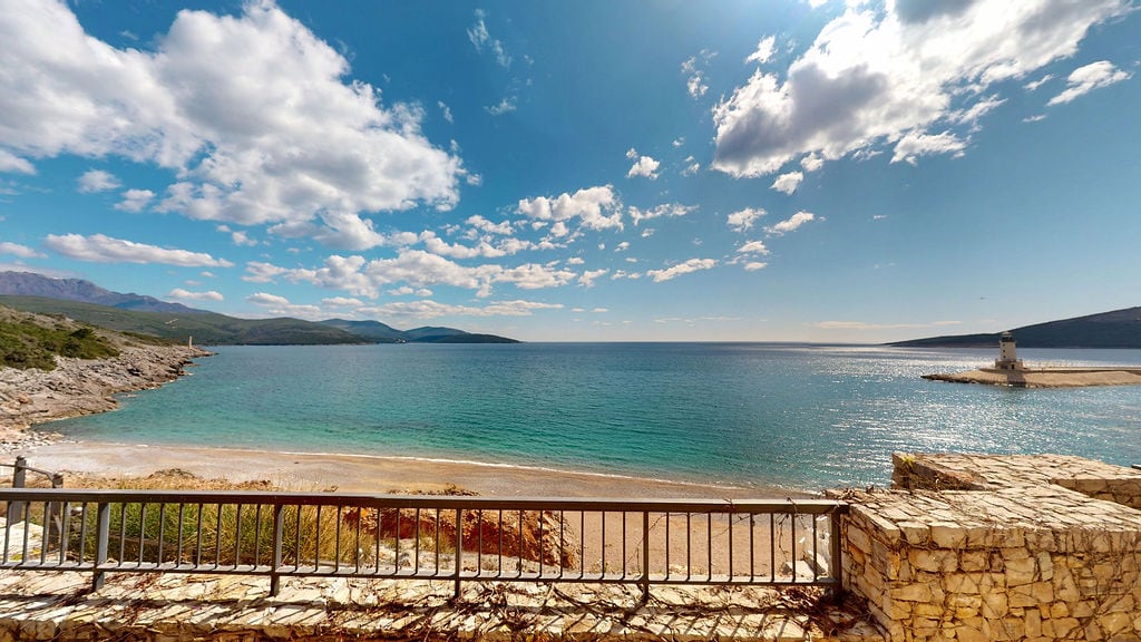 Karadağ, Luštica konut kompleksinde balkondan deniz, plaj ve deniz feneri manzarası: panoramik deniz manzarası ve taş kaplama.