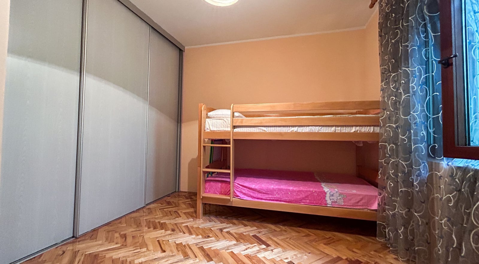 Kinderzimmer mit Etagenbett und eingebautem Schiebetürenschrank in einer Villa in Dobrota, Montenegro.