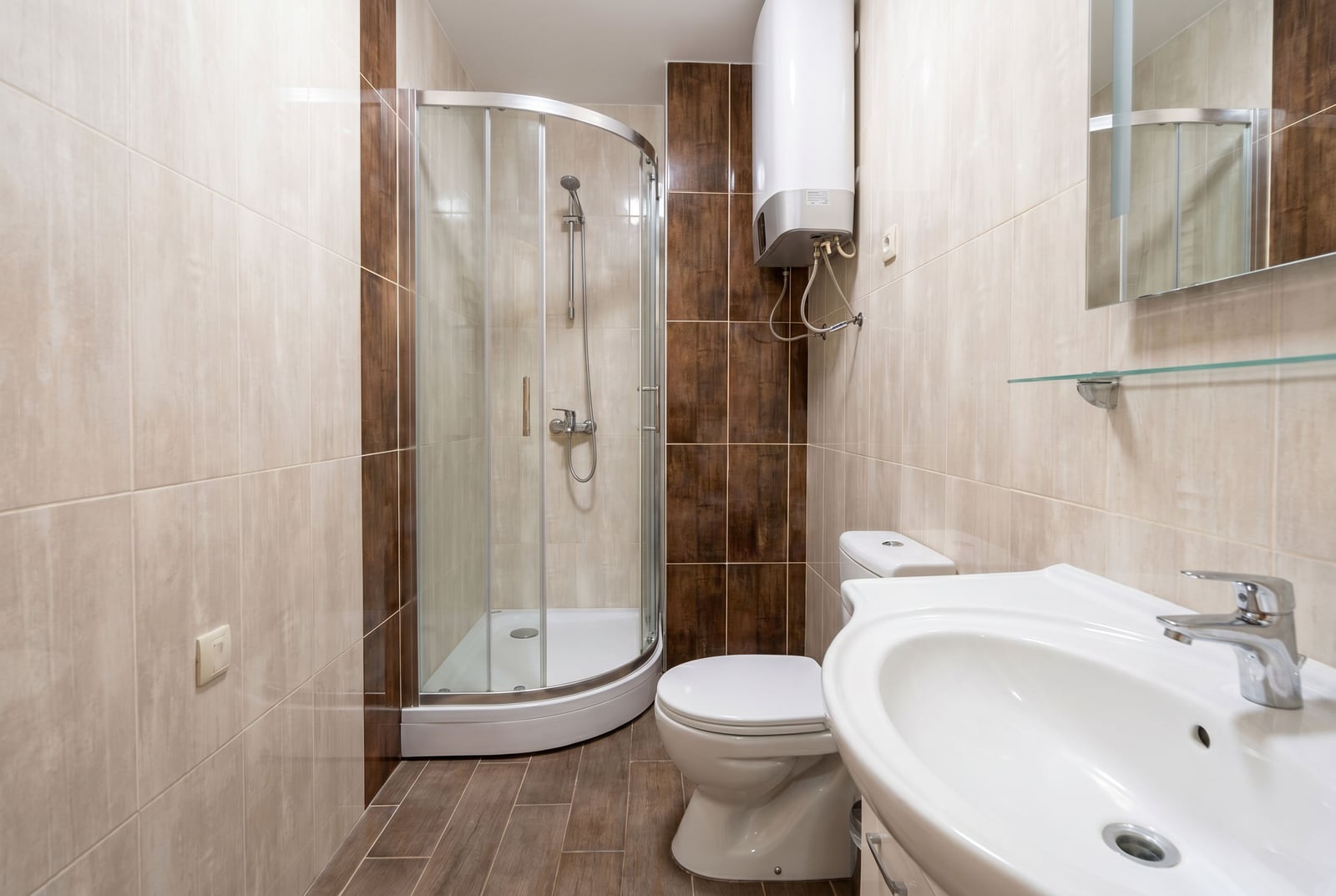 Modern bathroom with a walk-in shower in an apartment, Rafailovici, Montenegro: tiling, sanitary ware, and water heater.