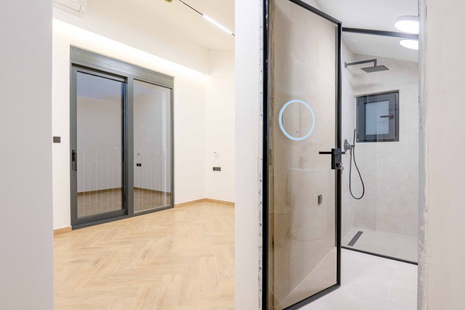 Chambre moderne avec fenêtre panoramique et salle de bains dans une nouvelle villa, Kamenovo, Monténégro. Intérieur lumineux.